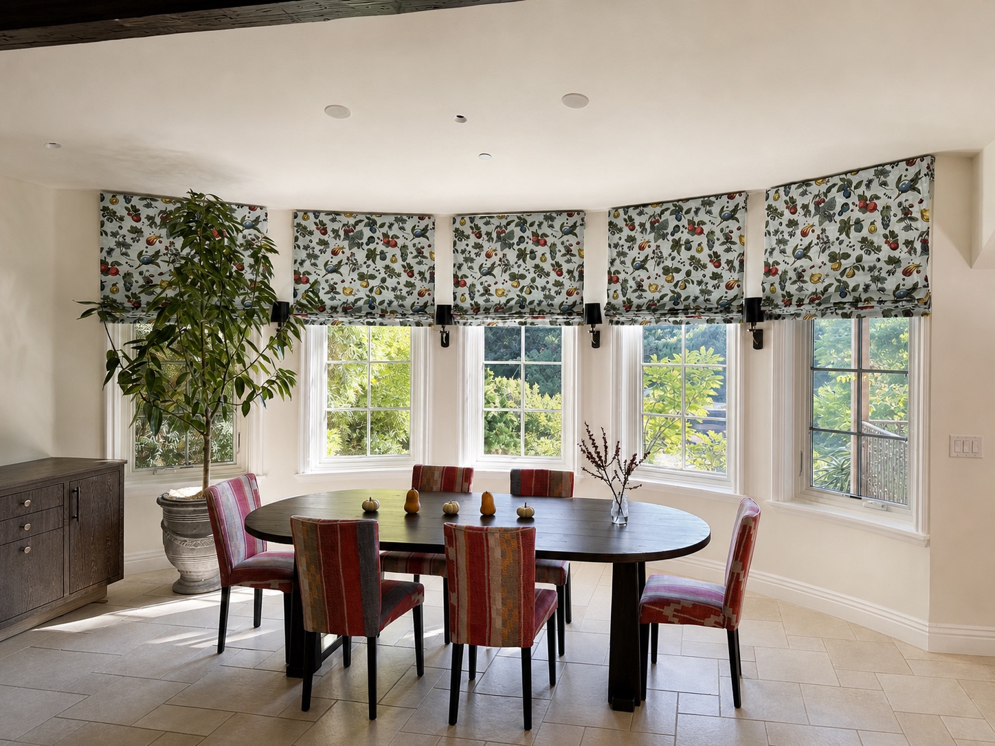Custom flat Roman shades in Schumacher Berry Grove Sky fabric across a curved dining room window bay