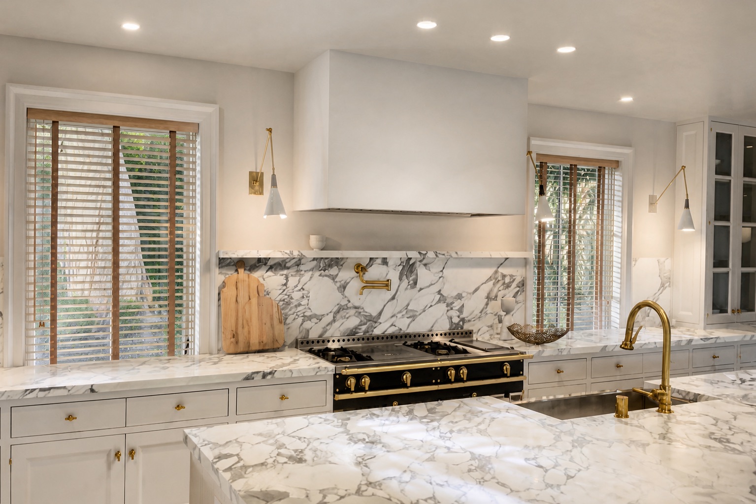 Custom two-inch wood blinds with coordinating contrast ladder tape in a marble residential kitchen