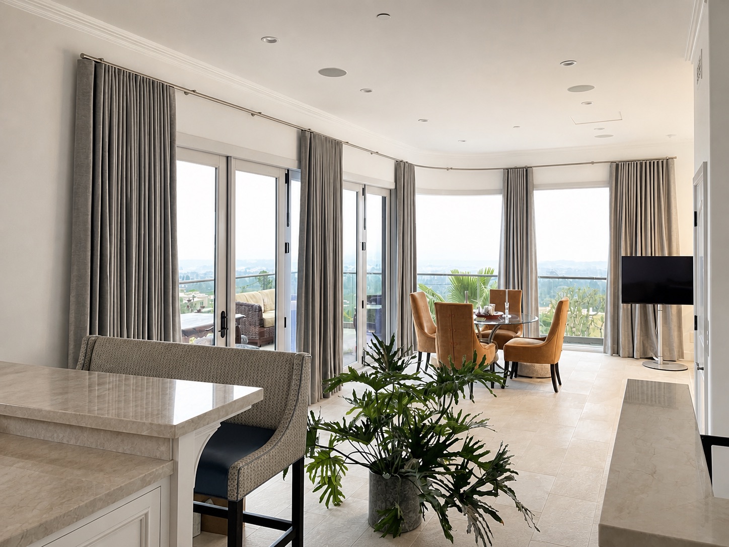 Ripple fold drapery on a custom curved designer track across a curved wall of residential windows